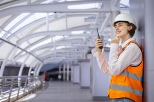 Caucasian woman engineer is using walkie talkie while inspecting the construction project for modern architecture and real estate development concept photo