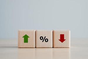 Interest rate finance and mortgage rates concept. Wooden block with percentage and direction of arrow that going down or up. Business and financial concept. inflation, sale price, loan and tax.