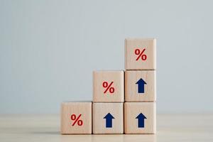 Interest rate finance and mortgage rates concept.  Wooden blocks with blue arrow up and red percentage sign, financial growth, interest rate increase, inflation, sale price and tax rise concept. photo