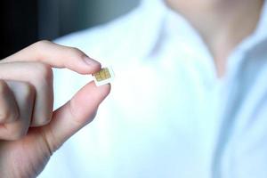 Man hand holding white sim card. Technology concept. photo