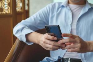 Cerca de un hombre usando un teléfono inteligente móvil. foto