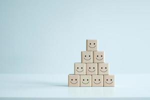 Smiling face icons on wooden cubes. Business service rating, customer satisfaction or teamwork concept. photo