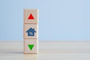 Interest rate finance and mortgage rates concept. Real estate, House, property investment, asset management, house tax, loan. house icon with percentage on wooden block and up and down of arrow. photo