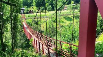 Red old metal structure with wooden pathway bridge in nature in Georgia countryside. Adjara hidden gems video