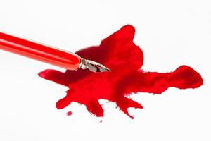 sharp nib in red dip pen over red ink stain photo