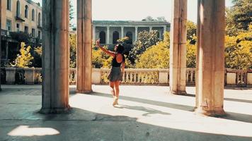 Beautiful caucasian woman taking photograph in Tsqaltubo abandoned palace.Travel Georgia holiday destination video