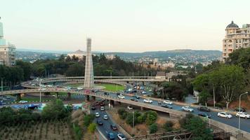 tbilisi, Georgië - 15e juli, 2022 - antenne visie auto's in verkeer Aan rotonde in tbilisi centrum. plein van heroes monument video