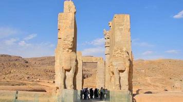 Persepolis, Iran, 2022 -tourist stand by giant statues - Gates of all nations. Entrance to remains of historical persian city in Persia