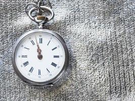 retro pocket watch on silver textile background photo