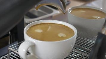 caffè estrazione a partire dal il caffè macchina con un' portafilter scrosciante caffè in un' tazza, espresso scrosciante a partire dal caffè macchina a un' bar video