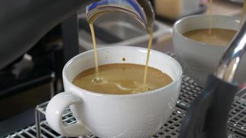 Coffee extraction from the coffee machine with a portafilter pouring coffee into a cup,Espresso pouring from coffee machine at a cafe video