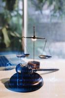 Justice and law concept.Male judge in a courtroom with the gavel, working with, computer and docking keyboard, eyeglasses, on table in morning light photo