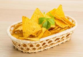 Nachos in a basket on wooden background photo