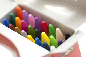 Open box of multicolored wax crayons