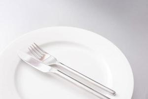 Clean white plate with knife and fork photo