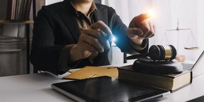 Business and lawyers discussing contract papers with brass scale on desk in office. Law, legal services, advice, justice and law concept picture with film grain effect photo