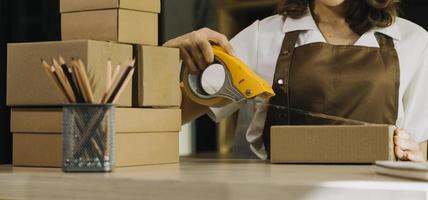 Portrait of Starting small businesses SME owners, two Asian woman check online orders Selling products working with boxs freelance work at home office, sme business online small medium enterprise photo