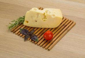 Maasdam cheese on wooden background photo