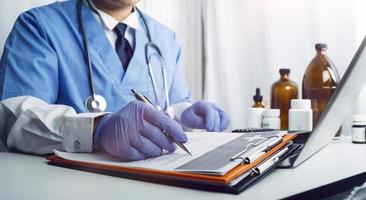 Medicine doctor hand working on a patients x-ray scans digital healthcare and connection with modern virtual screen interface icons, Medical technology and network concept. photo