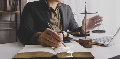 Justice and law concept.Male judge in a courtroom with the gavel, working with, computer and docking keyboard, eyeglasses, on table in morning light photo