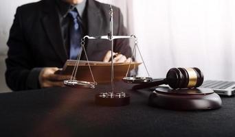 Business and lawyers discussing contract papers with brass scale on desk in office. Law, legal services, advice, justice and law concept picture with film grain effect photo