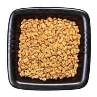 whole fenugreek seeds in black bowl isolated photo