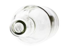 overturned empty clear brandy bottle isolated photo