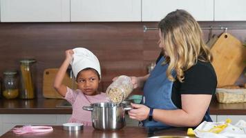 Young girl and adult woman in kitchen making cookies video