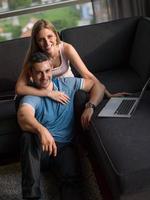 Attractive Couple Using A Laptop on couch photo