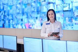 Female operator working in a security data system control room photo
