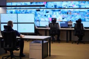 male operator working in a security data system control room photo