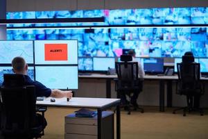 young male operator working in a security data system control room photo