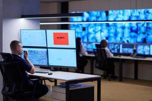 young male operator working in a security data system control room photo