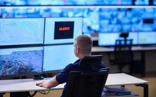 young male operator working in a security data system control room photo