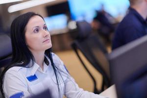 Female operator working in a security data system control room photo