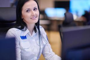 Female operator working in a security data system control room photo