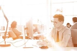 Young businessman using computer at work photo