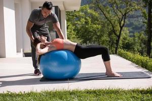 mujer y entrenadora personal haciendo ejercicio con pelota de pilates foto