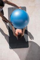 woman and personal trainer doing exercise with pilates ball photo