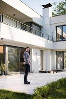 man in front of his luxury home villa photo
