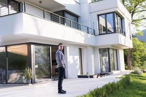 man in front of his luxury home villa photo