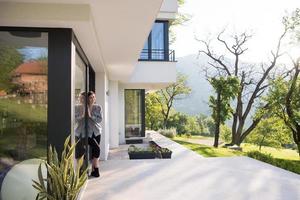 woman in front of her luxury home villa photo