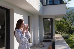 woman in a bathrobe enjoying morning coffee photo