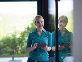 young women using tablet computer by the window photo