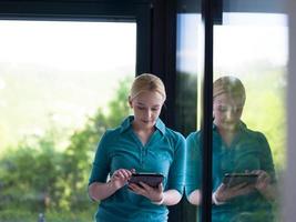young women using tablet computer by the window photo