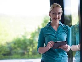 young women using tablet computer by the window photo