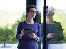 young women using tablet computer by the window photo