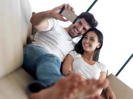 pareja joven haciendo selfie juntos en casa foto