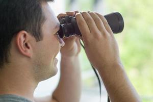 hombre mirando con binoculares foto