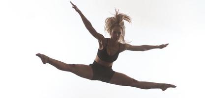 bailarina de ballet deportivo femenino delante de un fondo blanco foto